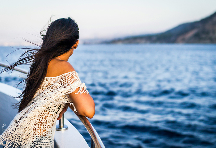 A lady looking at the views from the deck of a ship